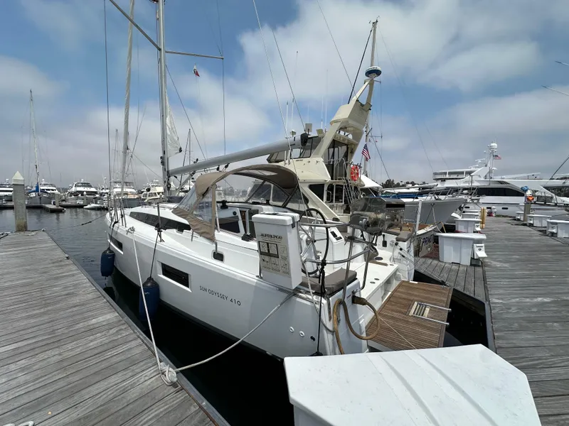 Slide: The Image of 2020 Jeanneau Sun Odyssey 410 sailboat docked at marina under cloudy sky. - 14