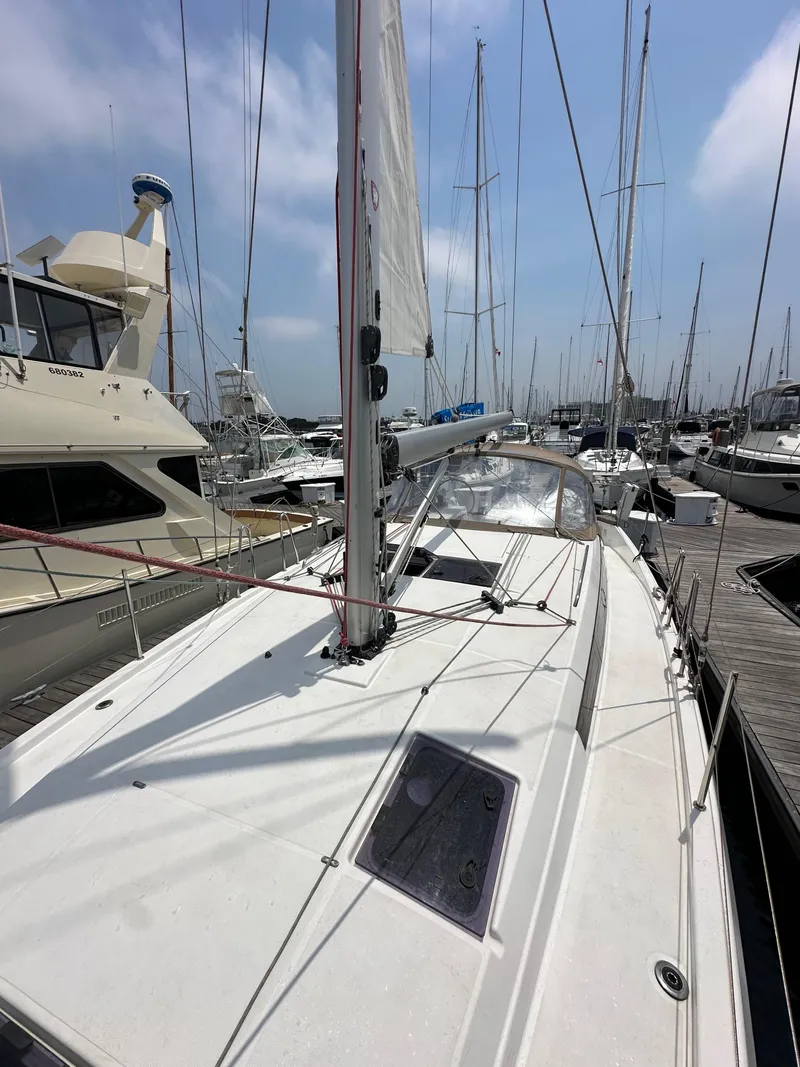 Slide: The Image of 2020 Jeanneau Sun Odyssey 410 sailboat docked in a marina under a clear sky. - 34