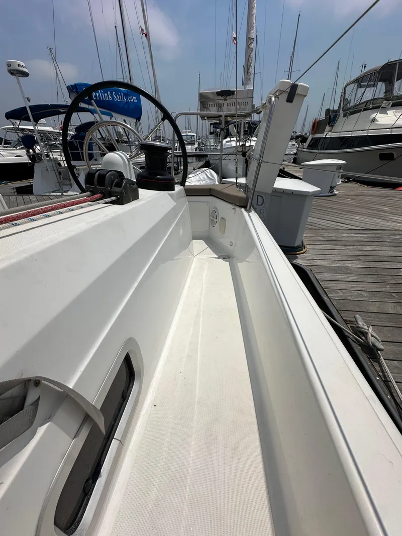 Slide: The Image of 2020 Jeanneau Sun Odyssey 410 sailboat docked, showcasing sleek deck design and steering wheel. - 41