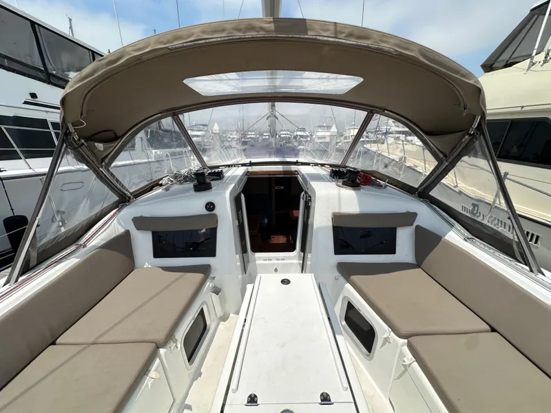 Slide: The Image of 2020 Jeanneau Sun Odyssey 410 cockpit with beige cushions and canopy, docked at marina. - 49