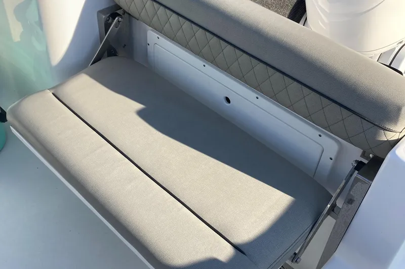 Slide: The Image of 2023 Sportsman Open 242 Center Console boat seat with gray upholstery and storage compartment. - 16