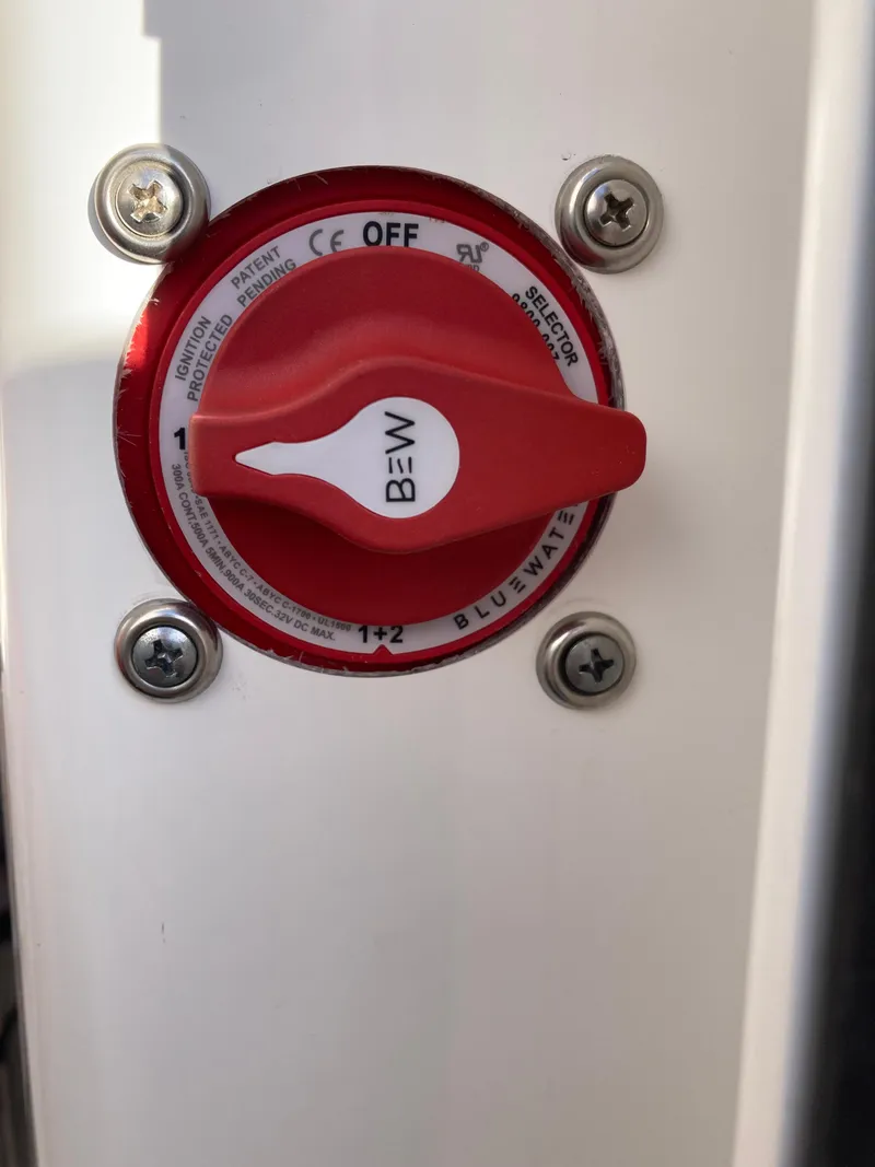 Slide: The Image of Red battery switch on 2023 Sportsman Open 242 Center Console boat. - 23