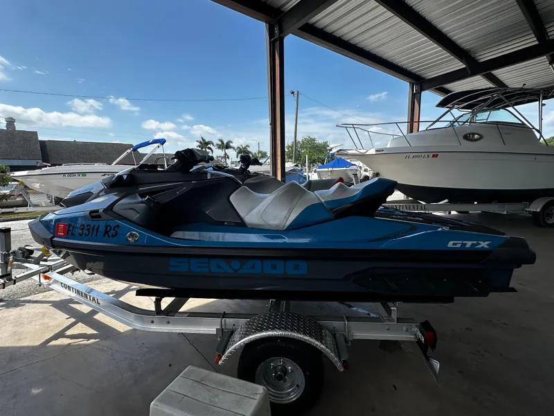 Slide: The Image of 2018 Sea-Doo GTX 230 jet ski on trailer in covered storage area. - 2