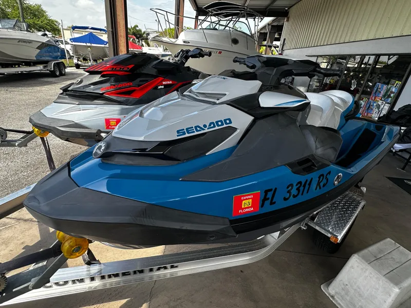 Slide: The Image of 2018 Sea-Doo GTX 230 jet ski in blue on a trailer, parked outdoors. - 3