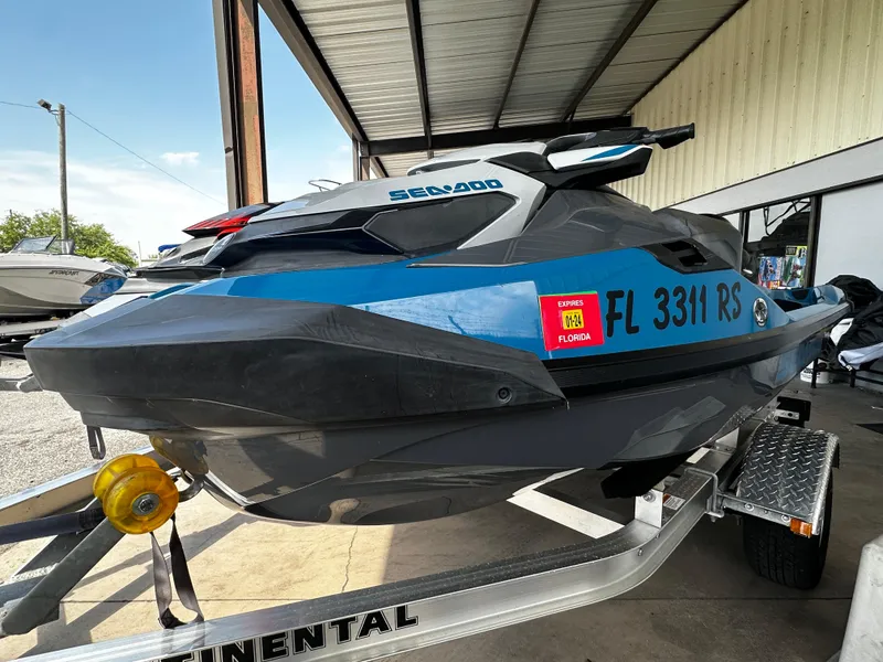 Slide: The Image of 2018 Sea-Doo GTX 230 jet ski on trailer, blue and black, parked under a metal roof. - 4
