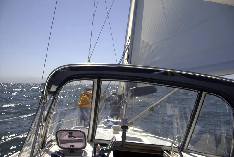 Slide: The Image of Sailing on a 1999 Hunter 380 yacht with crew on deck, under clear skies. - 12