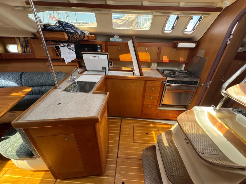 Slide: The Image of Interior of 1999 Hunter 380 sailboat with kitchen and seating area. - 22