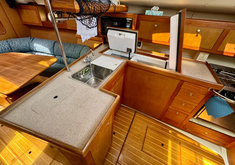 Slide: The Image of Interior of 1999 Hunter 380 sailboat kitchen with wooden cabinetry and sink. - 24