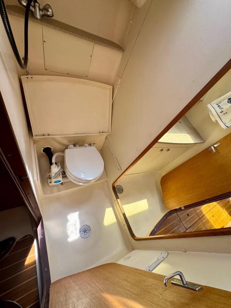 Slide: The Image of Bathroom interior of a 1999 Hunter 380 sailboat, featuring a toilet and sink. - 28