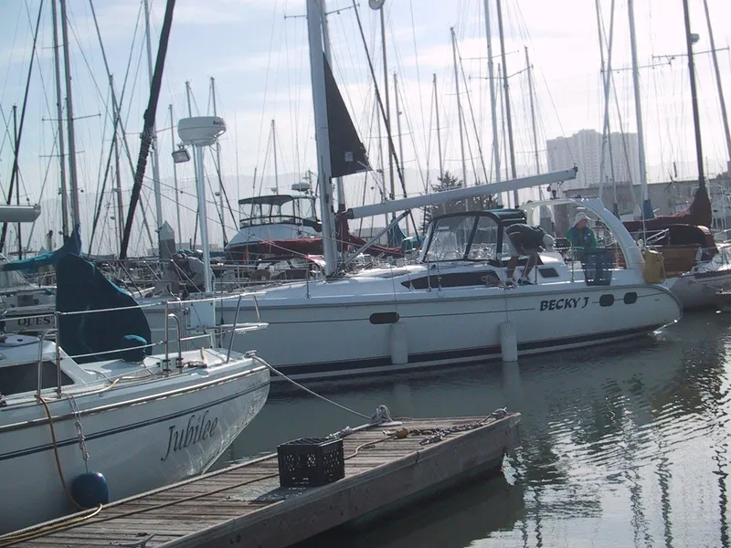 Slide: The Image of Sailboats docked at marina, featuring a 1999 Hunter 380 model. - 4