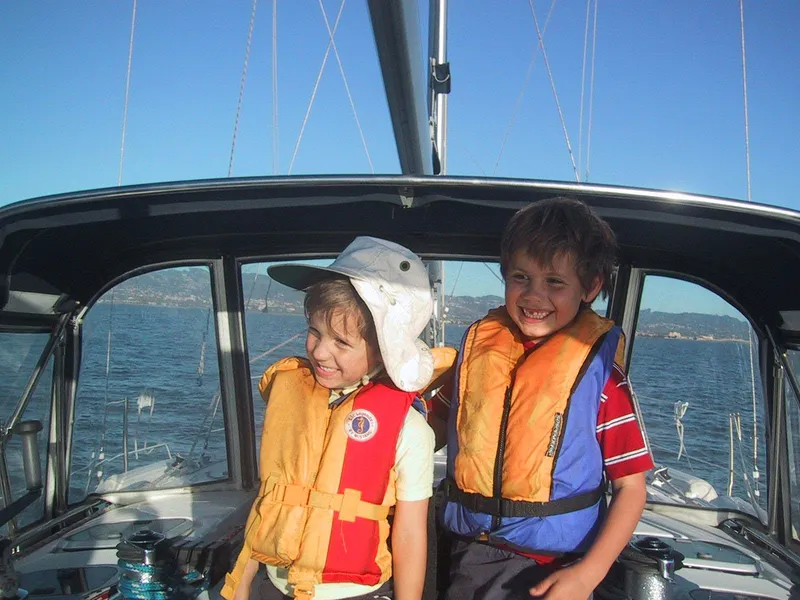 Slide: The Image of Children wearing life jackets on a 1999 Hunter 380 sailboat, enjoying a sunny day at sea. - 6