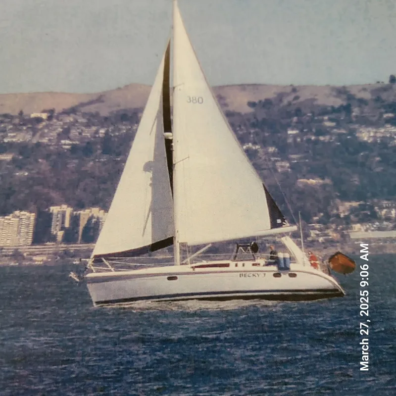Slide: The Image of Sailboat Hunter 380, 1999 model, cruising on water with cityscape background. - 8