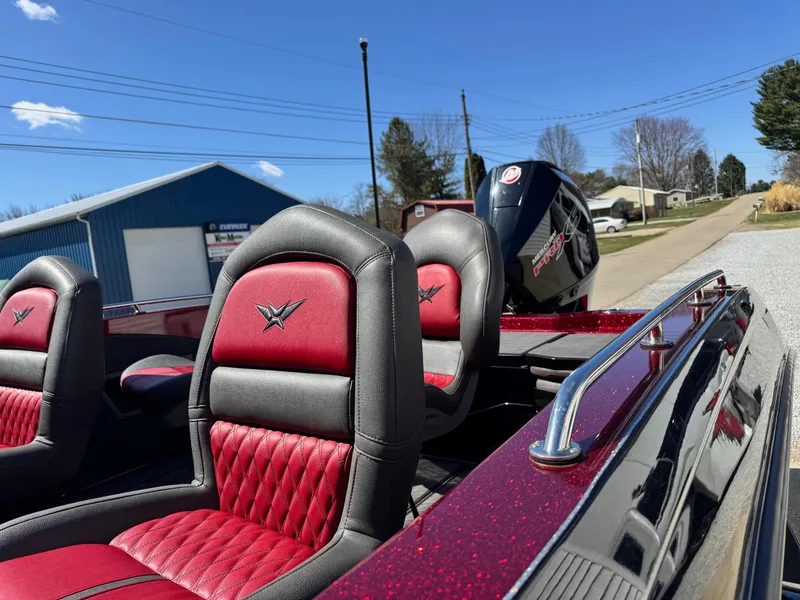 Slide: The Image of 2022 Vexus DVX20S boat with red and black seats, parked outdoors under a clear blue sky. - 10