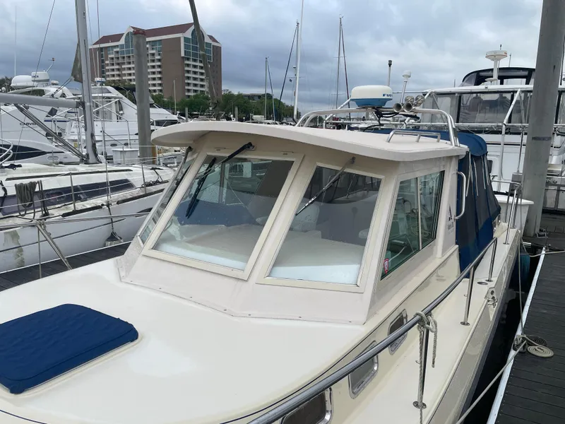 Slide: The Image of 2004 Albin 30 Family Cruiser docked at marina with modern buildings in background. - 10