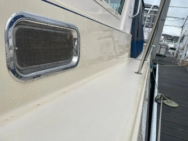 Slide: The Image of 2004 Albin 30 Family Cruiser docked, showcasing side vent and deck details. - 11