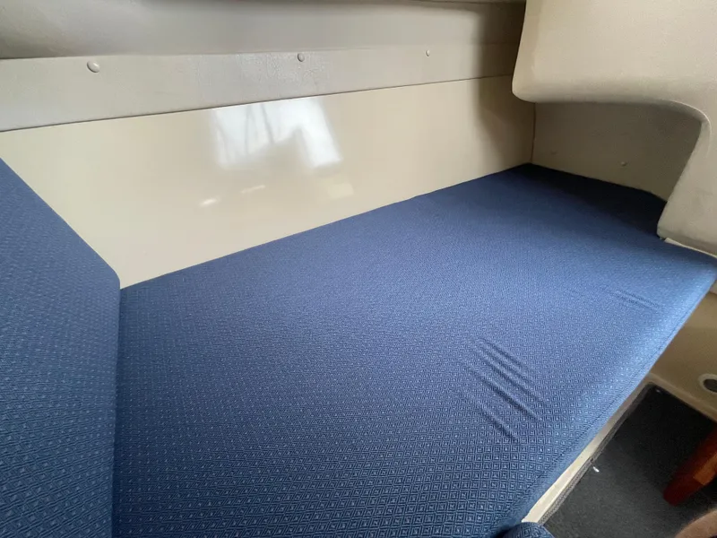 Slide: The Image of 2004 Albin 30 Family Cruiser interior with blue cushioned seating. - 25