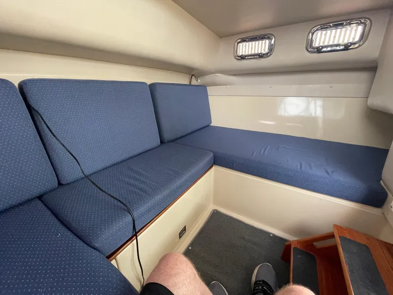 Slide: The Image of Interior of 2004 Albin 30 Family Cruiser with blue cushioned seating. - 28