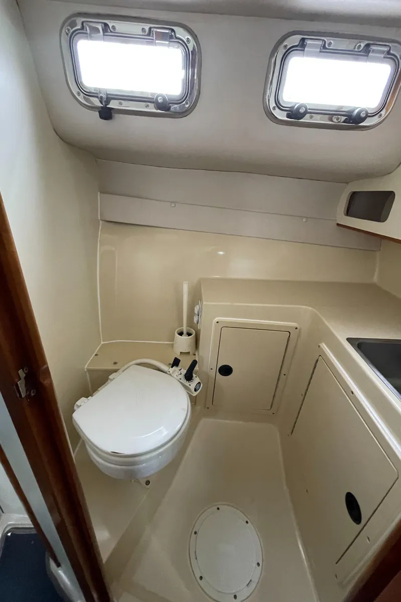 Slide: The Image of 2004 Albin 30 Family Cruiser bathroom with compact design and dual portholes. - 36