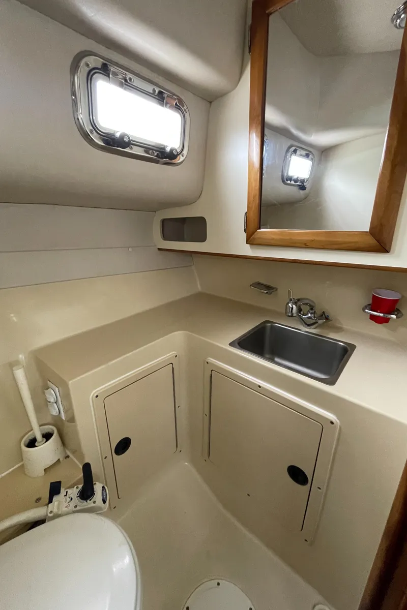 Slide: The Image of 2004 Albin 30 Family Cruiser bathroom with sink, mirror, and porthole window. - 37
