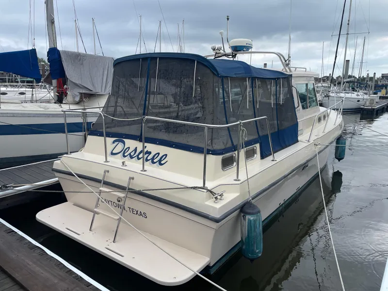 Slide: The Image of 2004 Albin 30 Family Cruiser docked at marina, featuring blue canopy and "Destree" on stern. - 7