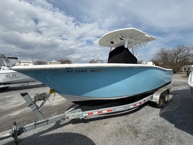 Slide: The Image of 2018 Sea Pro 239 Center Console boat on trailer, light blue hull, parked outdoors. - 1