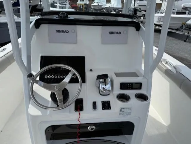 Slide: The Image of 2018 Sea Pro 239 Center Console boat dashboard with steering wheel and Simrad electronics. - 8