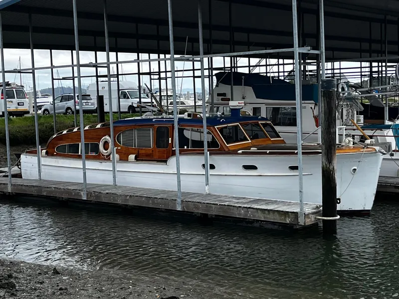 Slide: The Image of 1948 Chris-Craft Double Cabin boat docked in a marina under a covered shelter. - 0