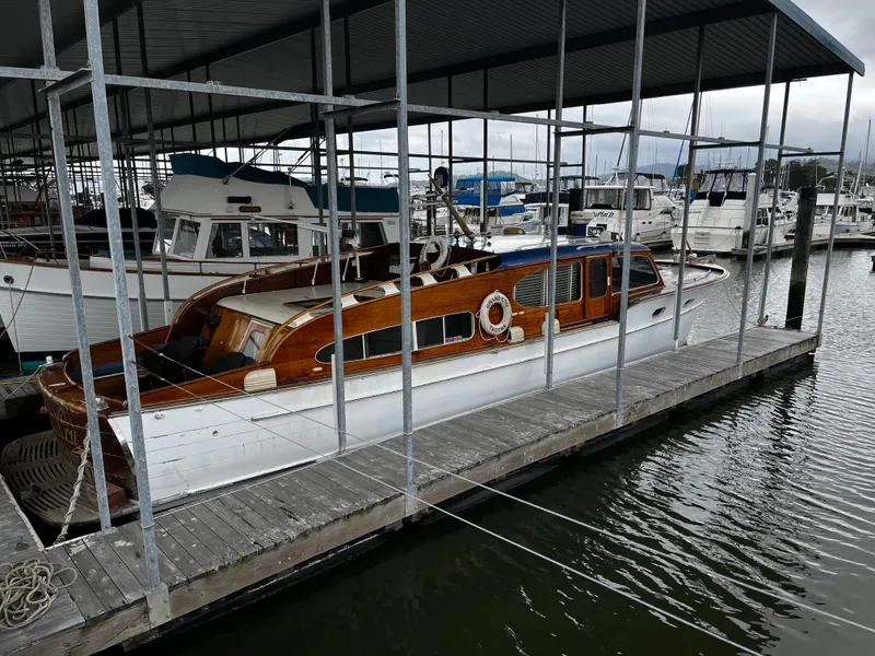 Slide: The Image of 1948 Chris-Craft Double Cabin boat docked in a marina under a covered shelter. - 2