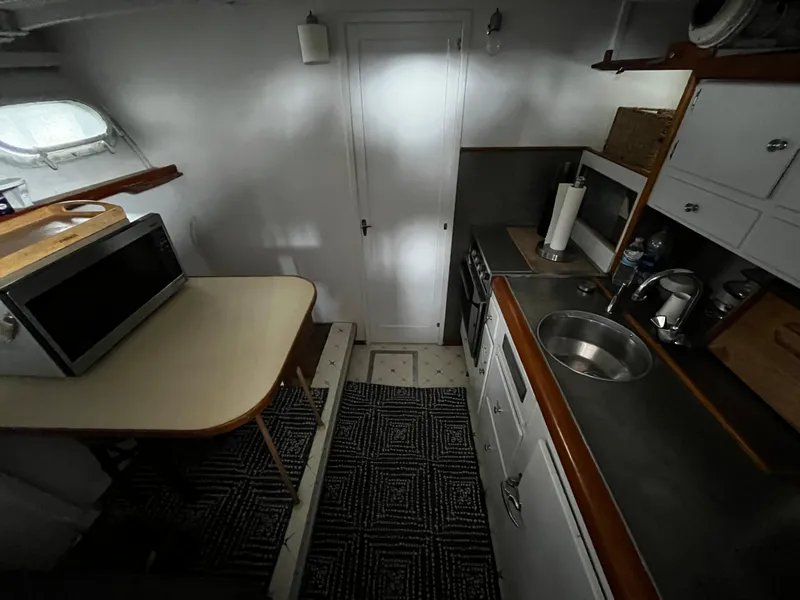 Slide: The Image of 1948 Chris-Craft Double Cabin interior with kitchenette, featuring sink, microwave, and storage cabinets. - 31
