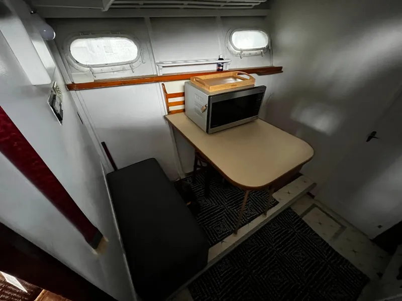 Slide: The Image of 1948 Chris-Craft Double Cabin interior with table, microwave, and seating. - 32