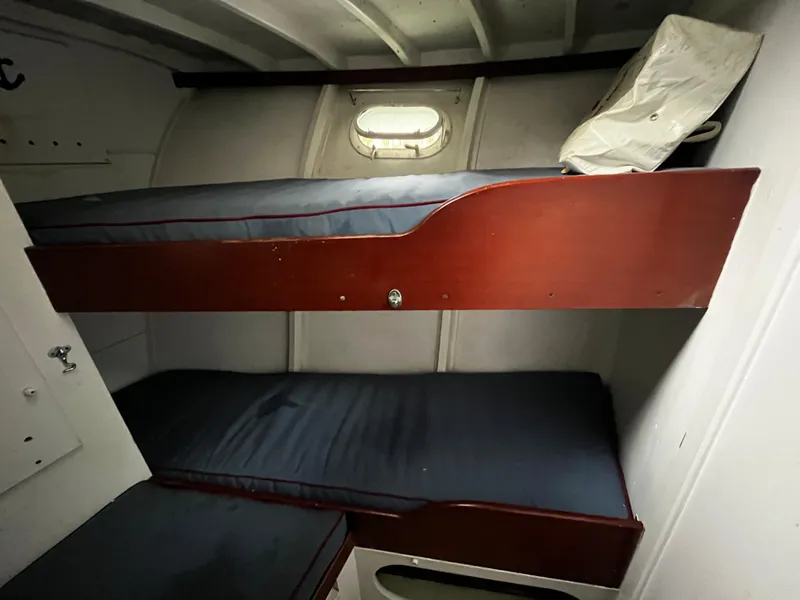 Slide: The Image of 1948 Chris-Craft Double Cabin interior with wooden bunk beds and porthole window. - 34
