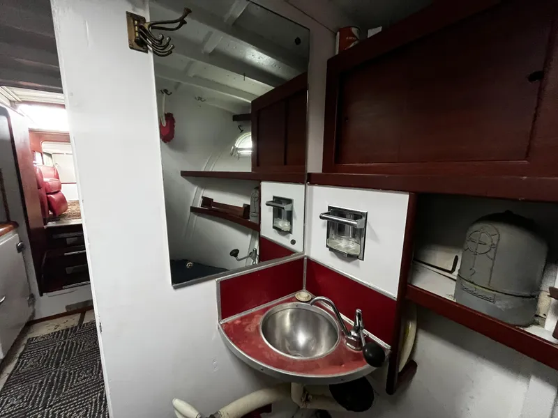 Slide: The Image of 1948 Chris-Craft Double Cabin bathroom with sink, mirror, and wooden shelves. - 37