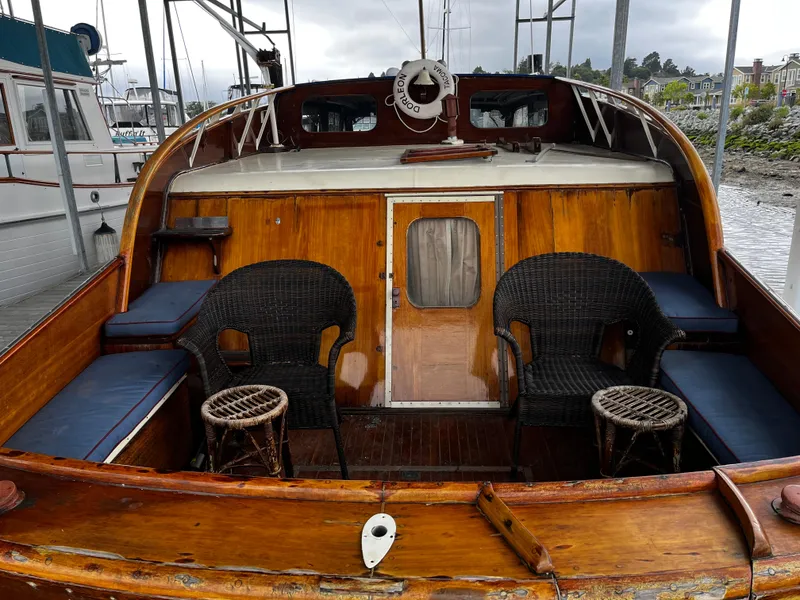 Slide: The Image of 1948 Chris-Craft Double Cabin boat with wooden deck, wicker chairs, and scenic marina backdrop. - 4