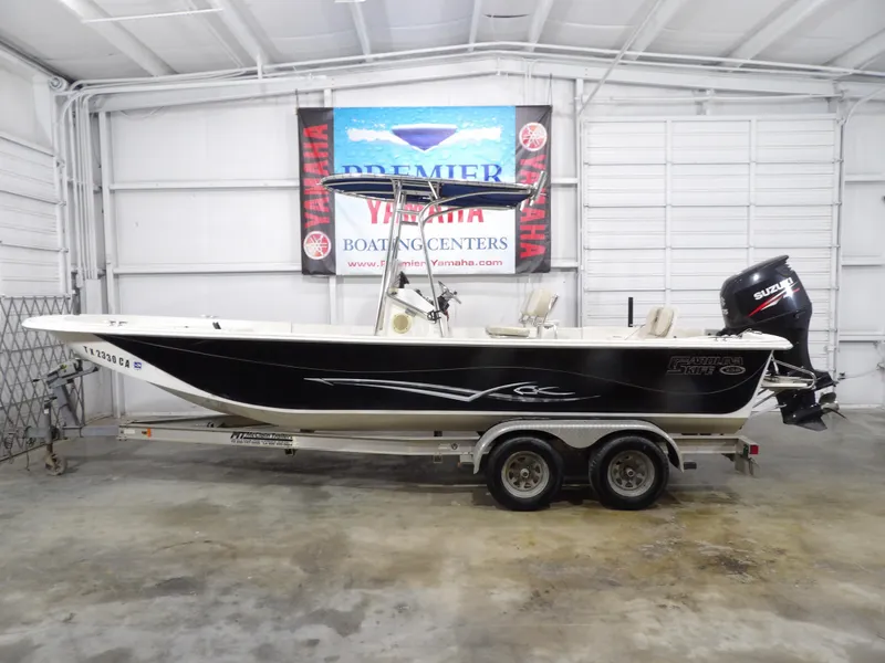 Slide: The Image of 2013 Carolina Skiff 238 DLV boat on trailer in indoor showroom. - 1