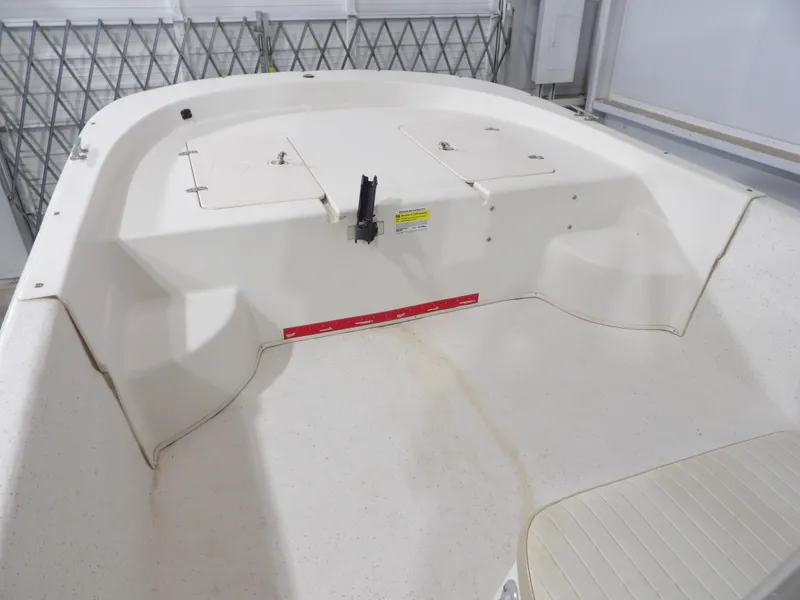 Slide: The Image of 2013 Carolina Skiff 238 DLV boat interior, featuring storage compartments and seating area. - 9