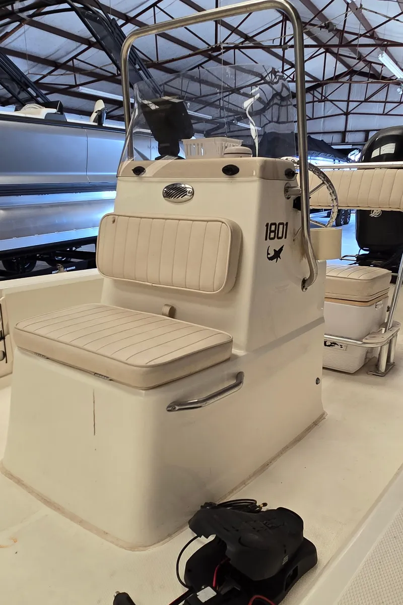 Slide: The Image of 2008 Mako Inshore 1801 boat interior with seating and console in a storage facility. - 10