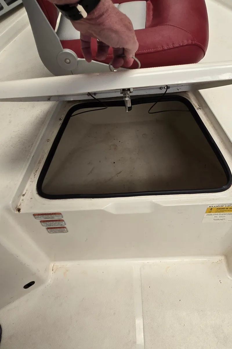 Slide: The Image of 2008 Mako Inshore 1801 boat storage compartment with red seat. - 12