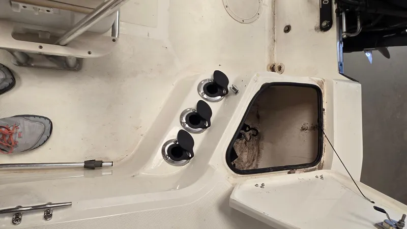 Slide: The Image of 2008 Mako Inshore 1801 boat interior with open storage compartment and rod holders. - 7