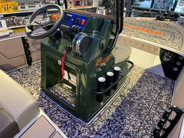 Slide: The Image of 2025 Mako 18 Pro Skiff Backwater Edition boat interior with camo flooring and steering console. - 2