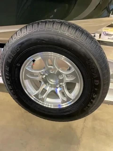 Slide: The Image of 2025 Mako 18 Pro Skiff Backwater Edition trailer tire with alloy wheel on display. - 3