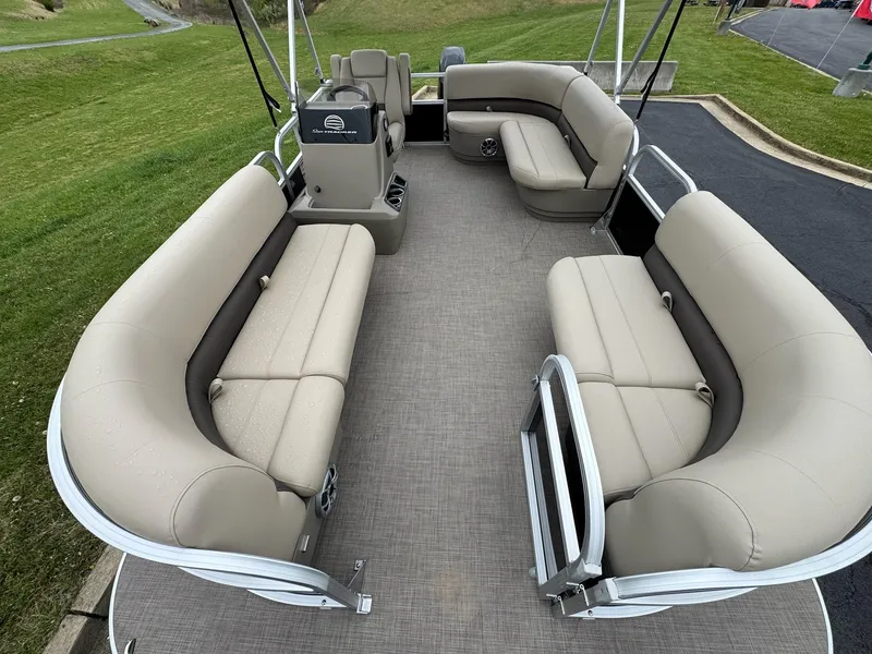 Slide: The Image of 2025 Sun Tracker Party Barge 16 DLX with spacious seating on a grassy area. - 6
