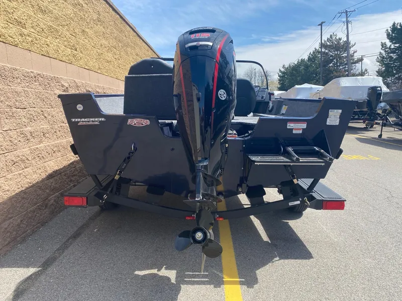 Slide: The Image of 2025 Tracker Pro Guide V-175 Combo boat with outboard motor, parked outdoors. - 3