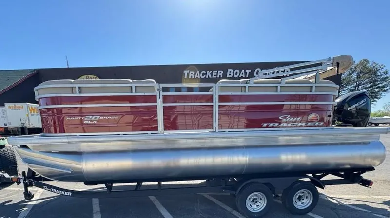 The Image of 2025 Sun Tracker Party Barge 20 DLX pontoon boat on trailer at dealership. - 0