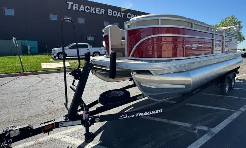 Slide: The Image of 2025 Sun Tracker Party Barge 20 DLX pontoon boat on trailer at dealership. - 4