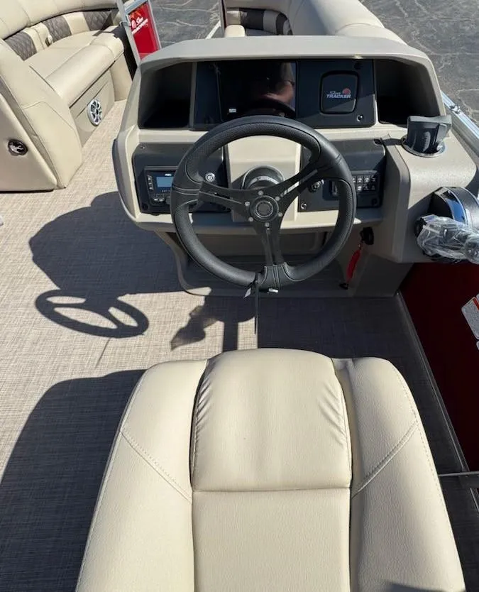 Slide: The Image of 2025 Sun Tracker Party Barge 20 DLX helm with beige seating and modern controls. - 5