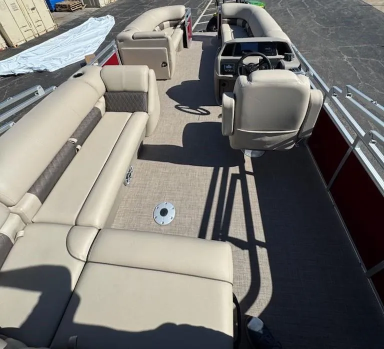 Slide: The Image of 2025 Sun Tracker Party Barge 20 DLX interior with beige seating and steering console. - 7