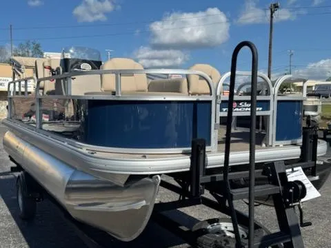 Slide: The Image of 2025 Sun Tracker Bass Buggy 18 DLX pontoon boat on trailer under blue sky. - 2