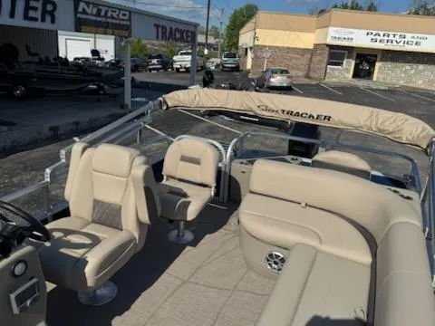 Slide: The Image of 2025 Sun Tracker Bass Buggy 18 DLX pontoon boat with beige seating and canopy. - 7