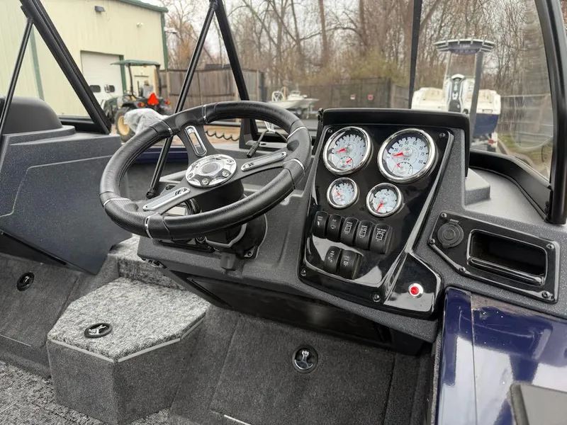 Slide: The Image of 2025 Tracker Targa V-18 Combo boat dashboard with steering wheel and gauges. - 2
