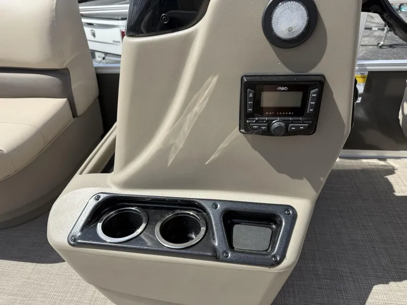 Slide: The Image of 2025 Sun Tracker Party Barge 16 DLX console with cup holders and audio controls. - 12